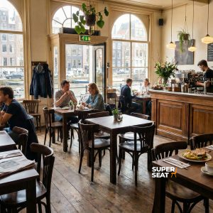 Super-Seat | Café avec des tables en bois, des piétements en acier noir, des chaises en bois, beaucoup de lumière et de plantes. | Mobilier de restauration