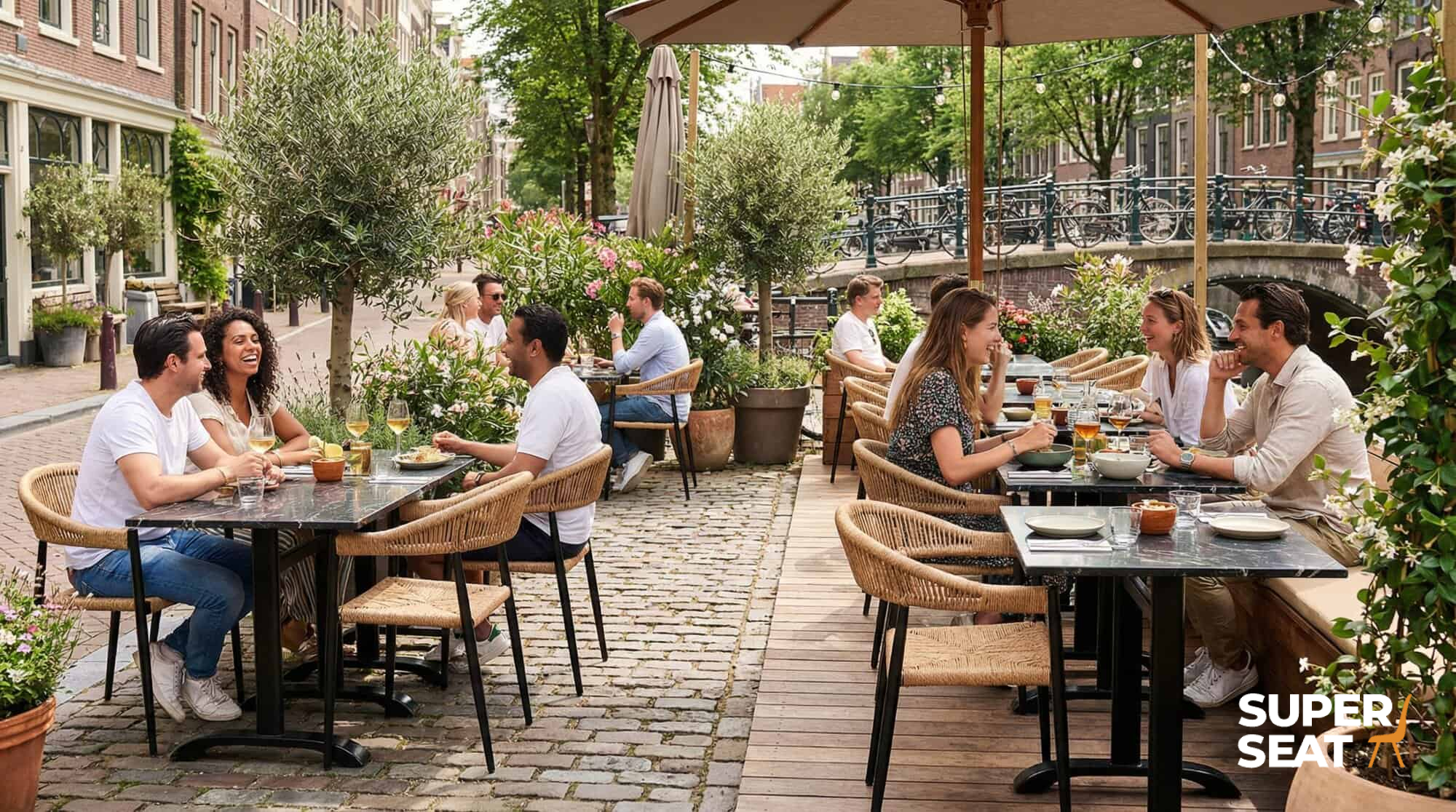 Super-Seat | Prague Terrace Chairs | Chaises en plastique tressé avec accoudoirs, tables noires ; café en plein air, au bord du canal. | Mobilier de restauration