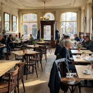 Super-Seat | Café Intérieur Tables en bois, chaises Thon courbées brunes avec barreaux, tabourets de bar et beaucoup de lumière dans l'espace. | Mobilier de restauration