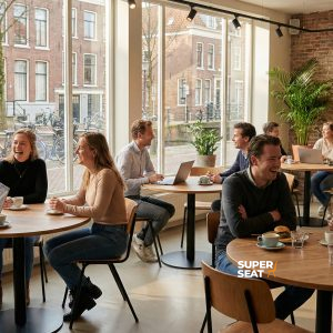 Super-Seat | Tables en mélaminé chêne château dans un café | Tables rondes en mélaminé chêne, chaises en métal, murs en briques, grandes fenêtres. | Mobilier de restauration