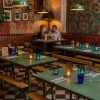 Super-Seat | Un restaurant confortable avec des tables pliantes militaires vintage | Tables pliantes en métal vert vintage, bancs en bois, carrelage noir/blanc, tasses en verre colorées. | Horecameubilair