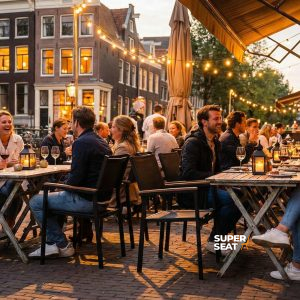 Super-Seat | Chaises en textile noir avec accoudoirs, tables en métal sur une terrasse en pavés. | Mobilier de restauration