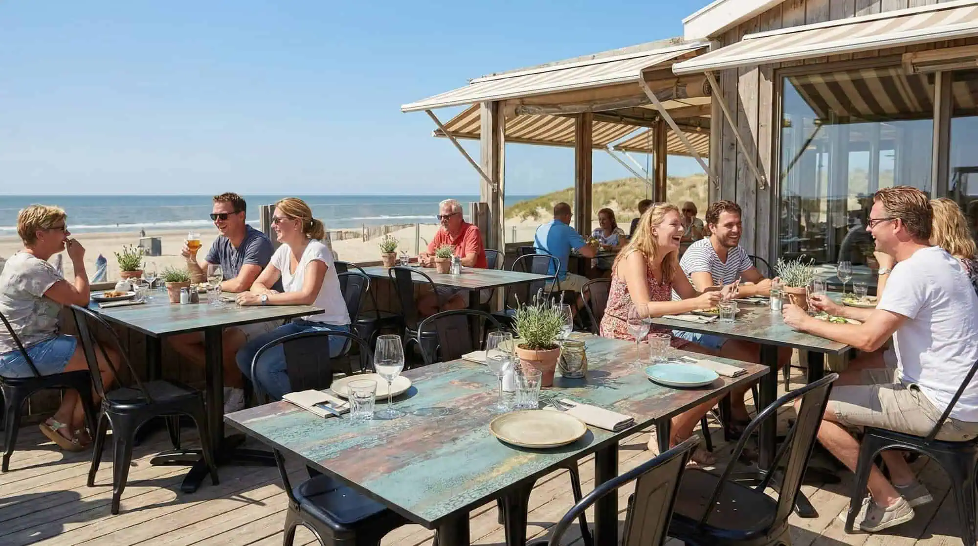 Super-Seat | Plateaux de table de terrasse rouille et cuivre Tables en HPL marron 70x70cm, sol de terrasse en bois entouré de plage, chaises dans des tons neutres. | Mobilier de restauration