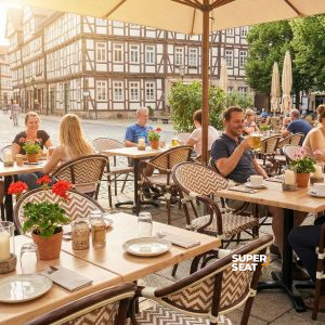Super-Seat | Chaises boho beige avec accoudoirs, tables en bois, tabourets de bar, parasols crème, place pavée. | Mobilier de restauration