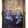 Super-Seat | Une photo en noir et blanc de religieuses avec l'art "CHEERS" en néon dans un cadre orné en bois doré | Zwart-wit kunstwerk in sierlijke gouden lijst, materiaal hout & neon, kleur zwart-wit/goud/neon. | Horecameubilair