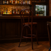 Super-Seat | Tabouret de bar Vienna Thon No 18 | Donkerbruin hout, gebogen rugleuning, bijpassende bar ; achtergrond flessen en koelkast. | Horecameubilair
