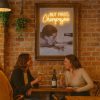 Super-Seat | Deux femmes dégustent du vin dans un restaurant confortable | Houten tafel, houten stoelen, bakstenen muur, vintage houten lijst, warme sfeer |. | Horecameubilair