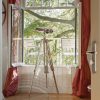 Super-Seat | Deux chaises en métal blanc sur un balcon, avec vue sur des arbres verts et un rideau rouge. | Mobilier pour la restauration