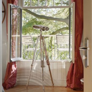 Super-Seat | Deux chaises en métal blanc sur un balcon, avec vue sur des arbres verts et un rideau rouge. | Mobilier pour la restauration