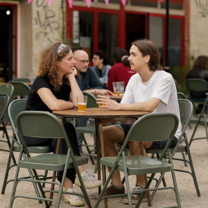 Super-Seat | Deux personnes sont assises l'une en face de l'autre à une table... | Table ronde en métal vintage, table ronde en métal, verres à boire en plastique. | Horecameubilair