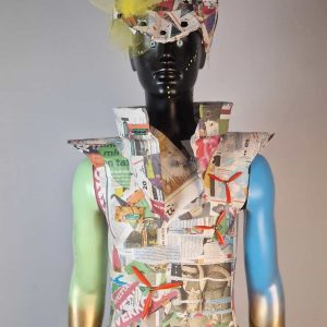 Super-Seat | Mannequin avec une tenue voyante en papier journal, tulle et pierres décoratives ; bras peints en bleu-or. | Mobilier de restauration