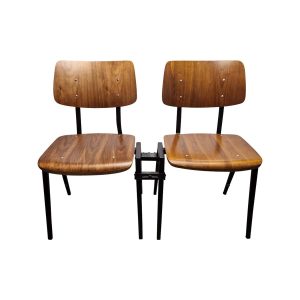 Super-Seat | Chaise de conférence Rietveld | Twee stoelen in bruin/zwart met gebogen hout, zwarte metalen poten en centrale verbindingsbeugel. | Horecameubilair