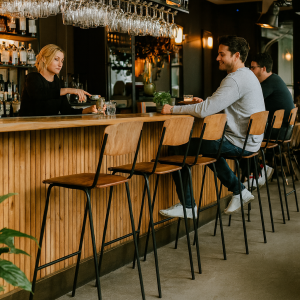 Super-Seat | Jazz Retro Hospitality Design | Velours moka stapelstoelen aan een moderne bar, houten blad, glazen schap met flessen. | Horecameubilair